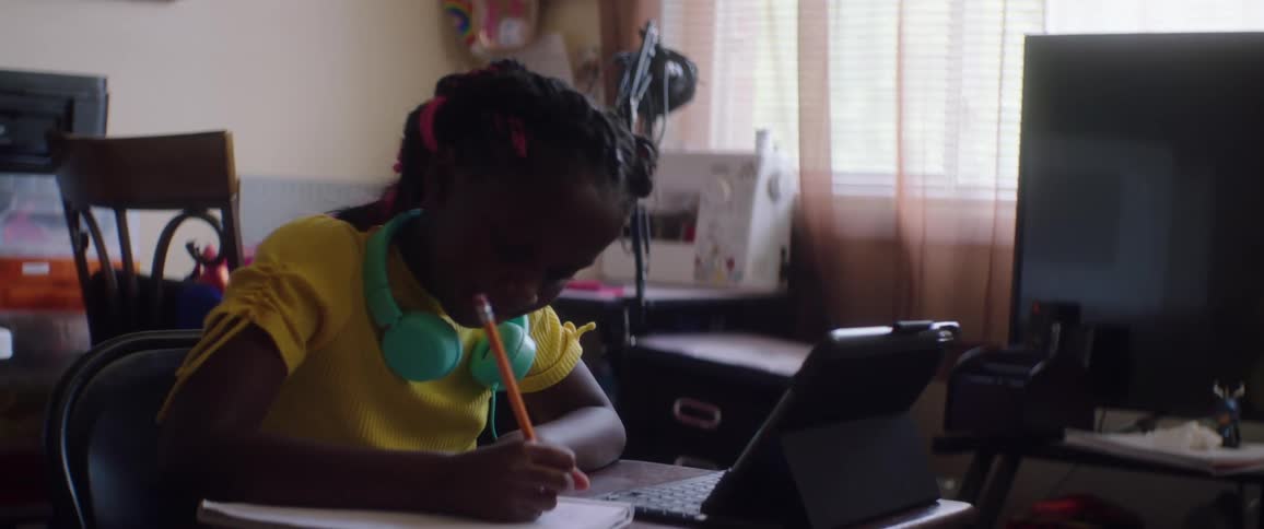 A child is working on schoolwork from home