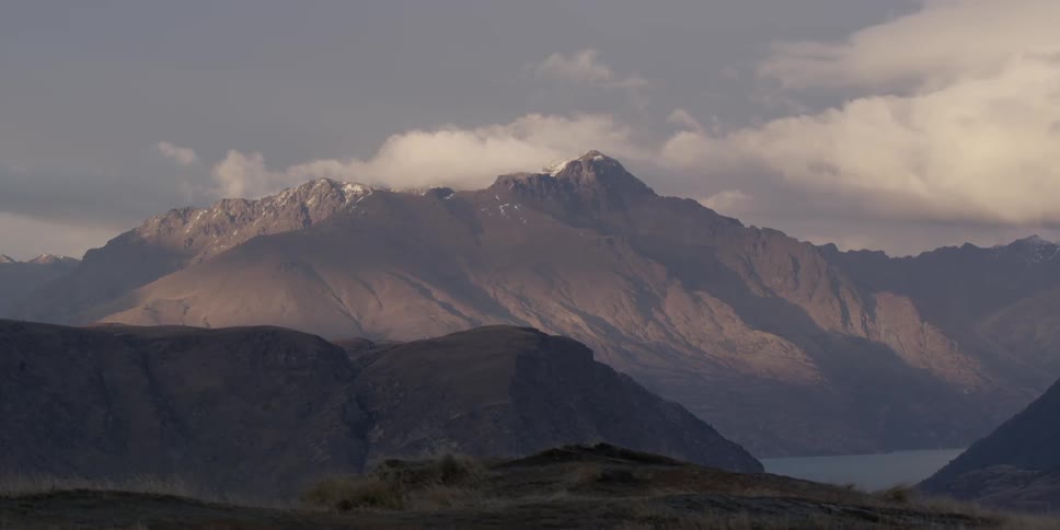 Clouds hovering over mountain peaks and a mountain lake