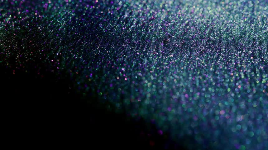 A liquid like substance twinkles and shines purple and blue sparkles as it moves