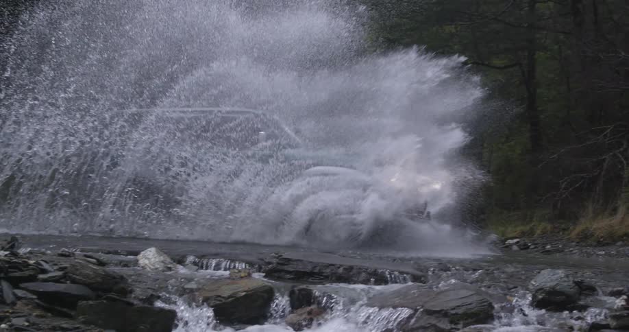 A car drives into a stream splashing water