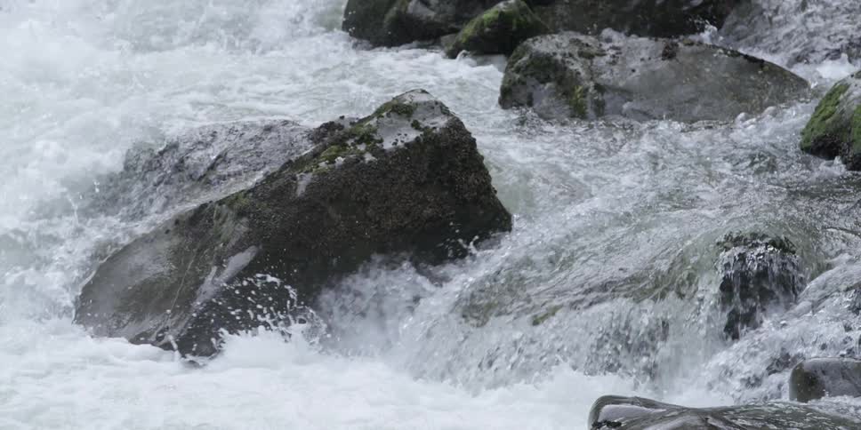 River water gushes over large rocks