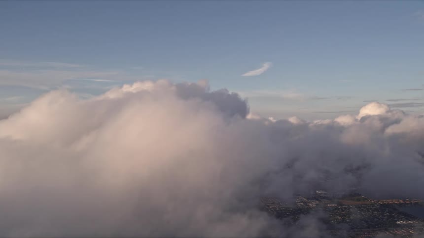Aerial footage of thick clouds enveloping Miamis skyline during sunset viewed from the east coast of southern Florida