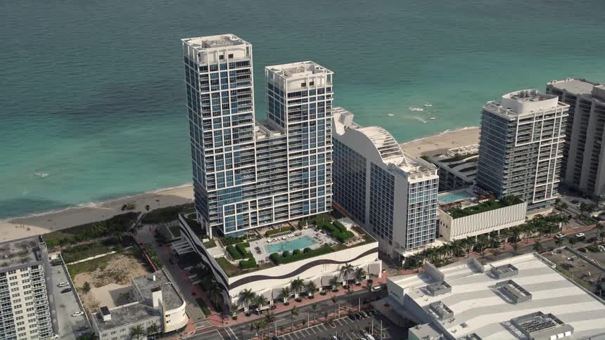 An breathtaking aerial view of a stunning oceanfront hotel situated on the beautiful sandy shoreline of Miami Beach in Floridas southern coast