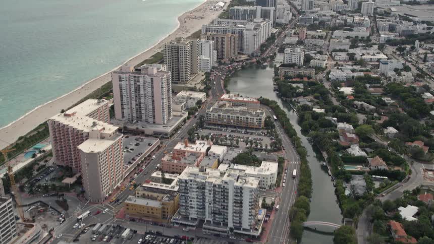 The aerial footage slowly tilts up from Indian Creek to reveal beautiful condominiums along the beach in Miami Beach Florida
