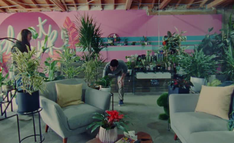 A man and woman arrange plants in a store