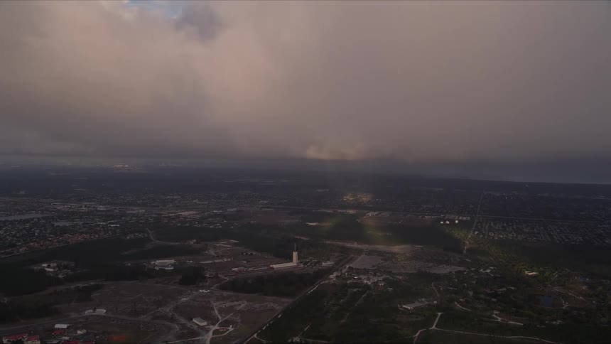 Aerial clip of a cloud formation at sunset near Zoo Miami Florida on the approach towards a misty town