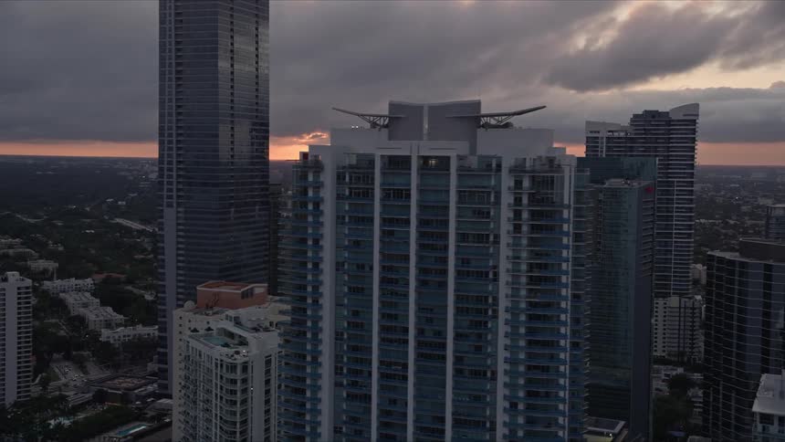 A stunning aerial flyby of Four Seasons Hotel and Jade at Brickell Bay at sunset in downtown Miami showcasing the citys high rise buildings and modern architecture