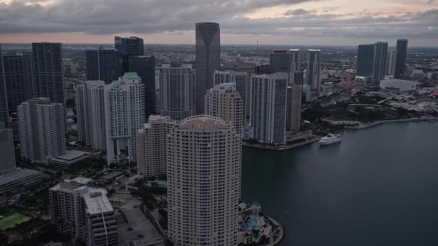 Aerial footage of Brickell Key skyscrapers during sunset overlooking the city river in Downtown Miami Florida