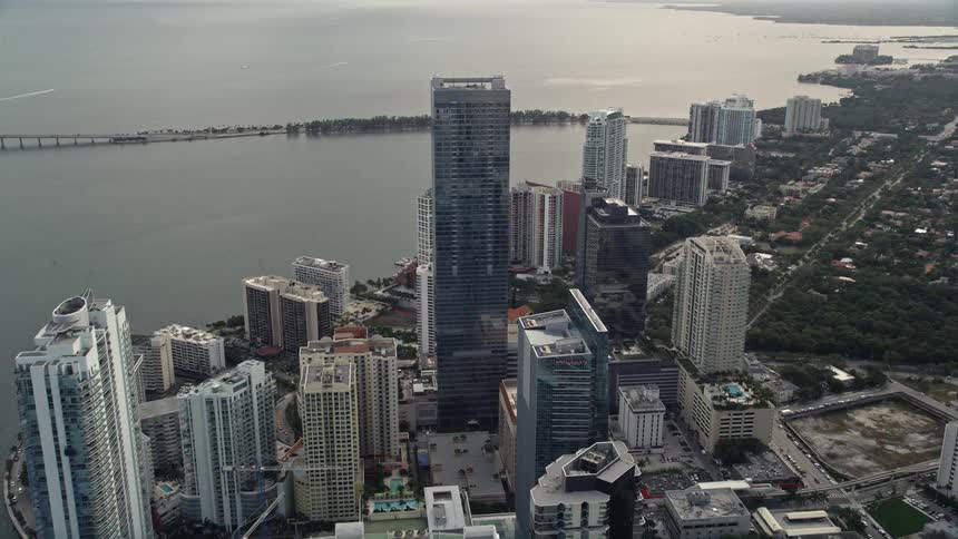 Approaching Four Seasons Hotel in Downtown Miami by flying over bayfront skyscrapers and high rise towers along the waterfront property of East Coast Florida