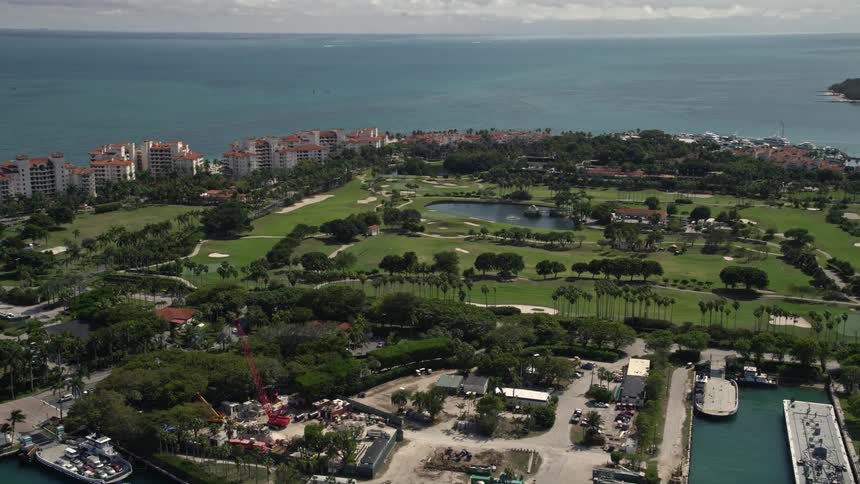 Aerial footage of a partly cloudy day on Fisher Island golf course in Miami Florida