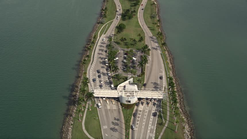 An aerial view of a sunny day approach to the Broad Causeway linking North Miami to the Bay Harbor Islands while car traffic moves below