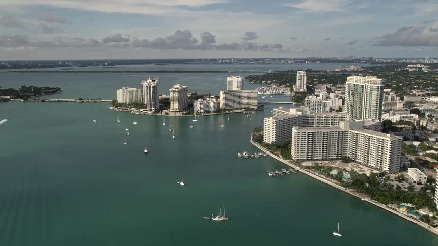 Approaching Belle Island the South Beach condos and hotels are seen from a 5k aerial view showcasing the waterfront property and shoreline of Biscayne Bay