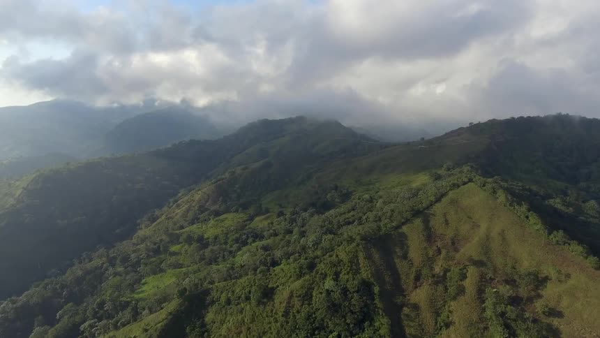 The hills in the distance are covered with clouds and grass
