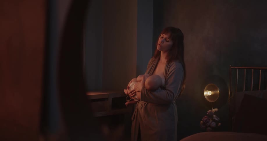 A woman rocks her baby while breastfeeding