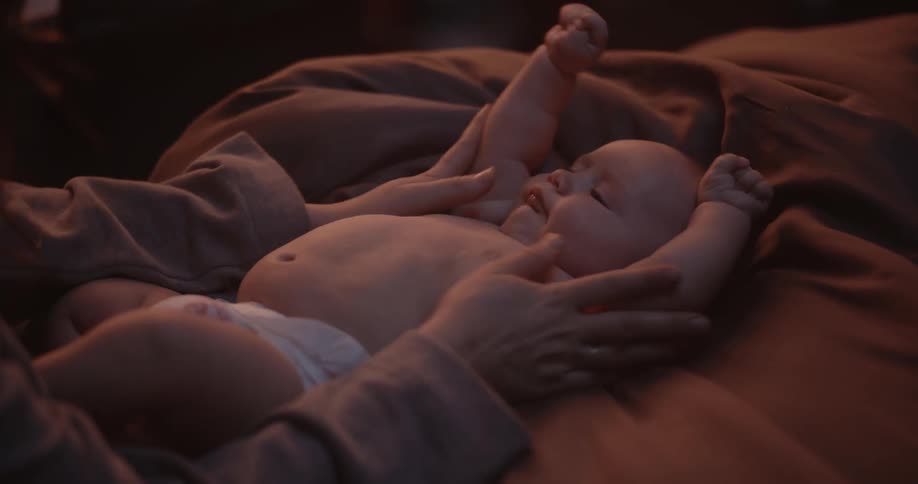 Mother plays with newborn baby with diaper