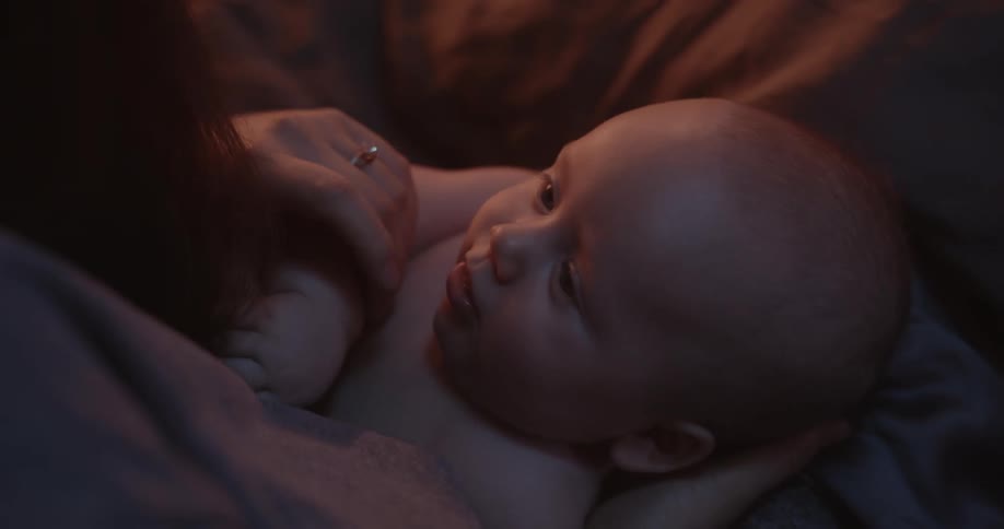 A woman touches her babys lips and nose