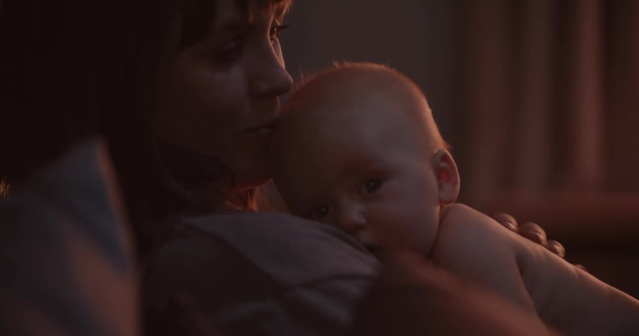 A mother hugs and cuddles her baby