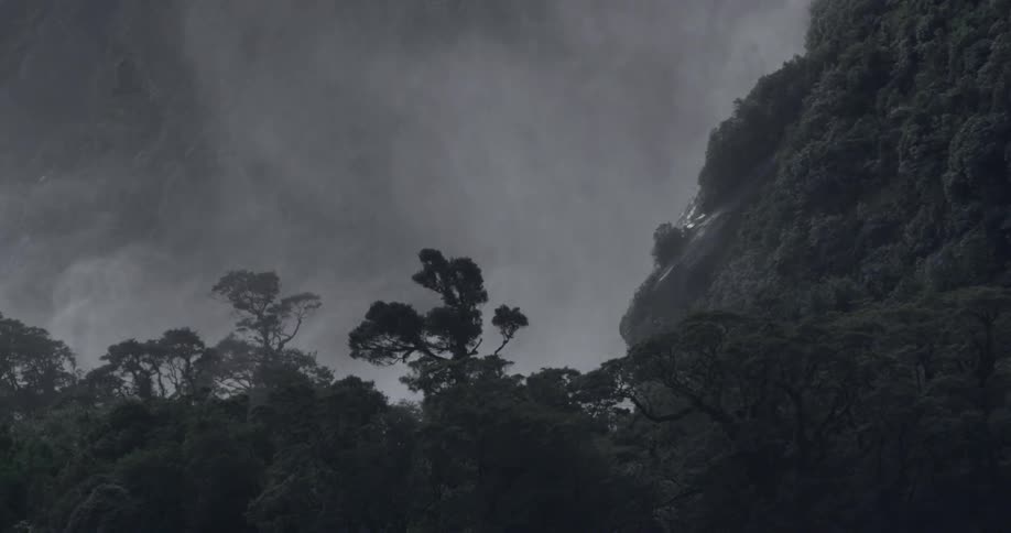 A high cliff has very dark clouds above