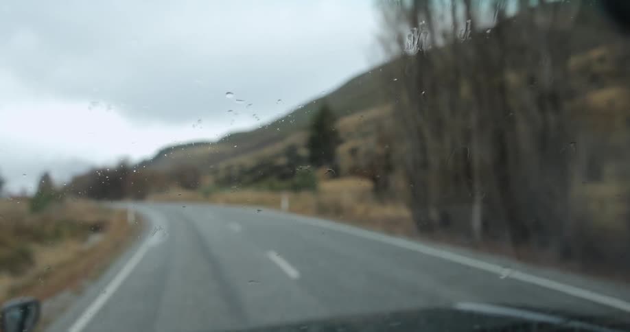 Sprinkles of rain being wiped away from windshield wipers