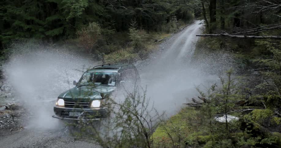 A car races downhill then through some water