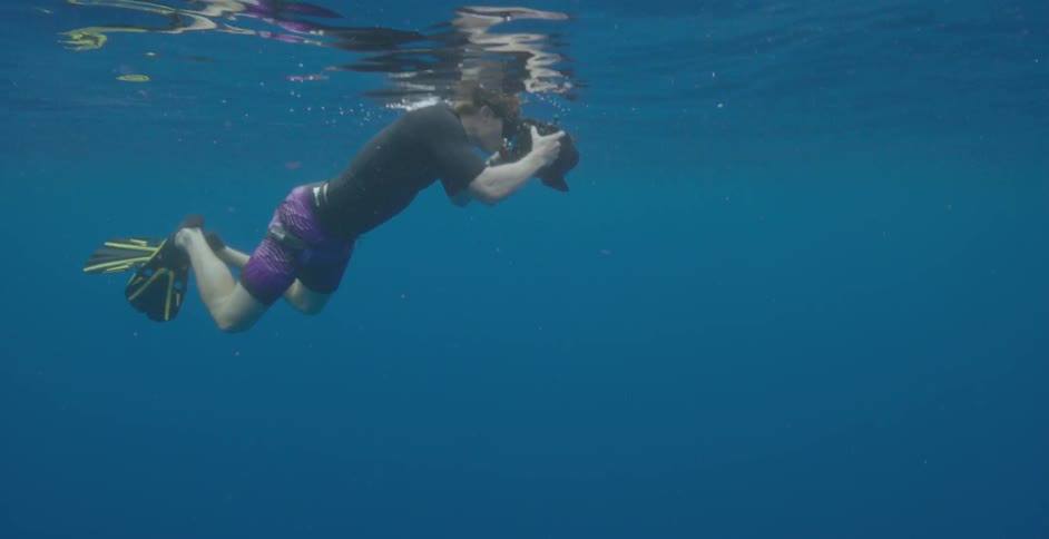 A man is taking photographs while swimming