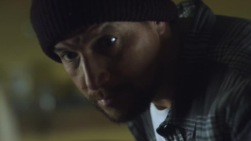 A close up of a man leaning over looking around