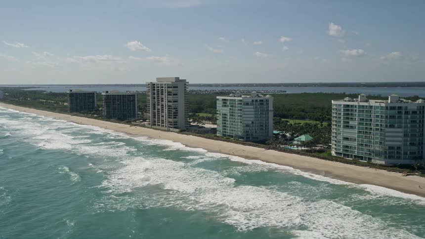 An aerial view of passing apartment buildings and the coastline of Jensen Beach Florida