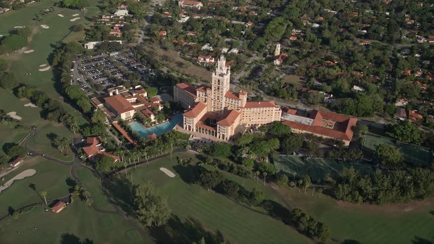 Fly over the Coral Gables Biltmore Hotel in Florida with its stunning golf course and beautiful surroundings on a sunny day