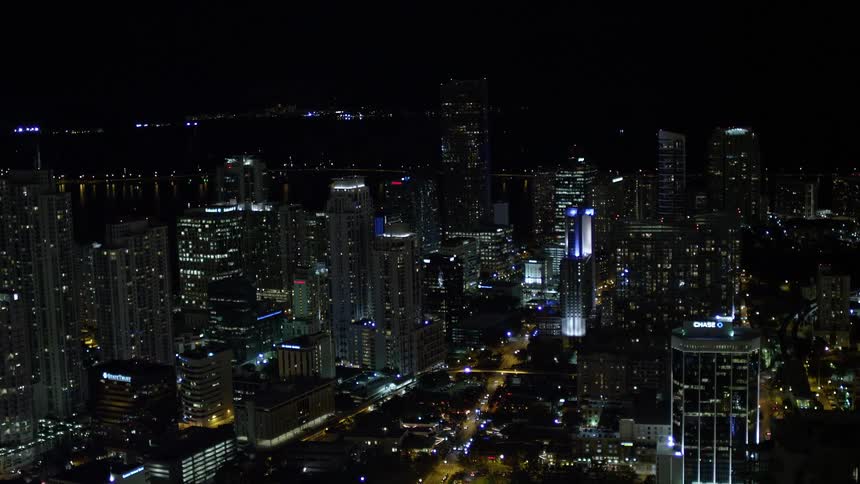 A stunning aerial view of Downtown Miamis illuminated skyscrapers captured at night in clear weather conditions showcasing the metropolis in its splendor