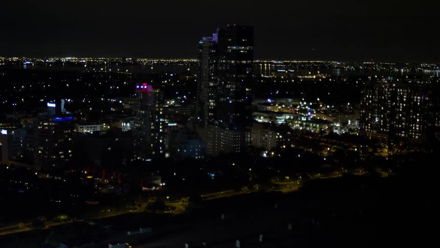 An aerial view of a beachfront hotel illuminated at night in Miami Beach Florida