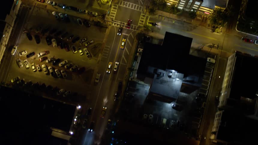 A stunning birds eye view of South Beach at night showing the bustling street full of cars driving along Collins Avenue