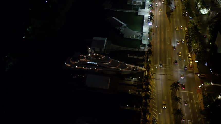 Orbit around Fontainebleau Miami Beach Resort Hotel and yacht at night showcasing the clear stunning views of the city and transportation on the water