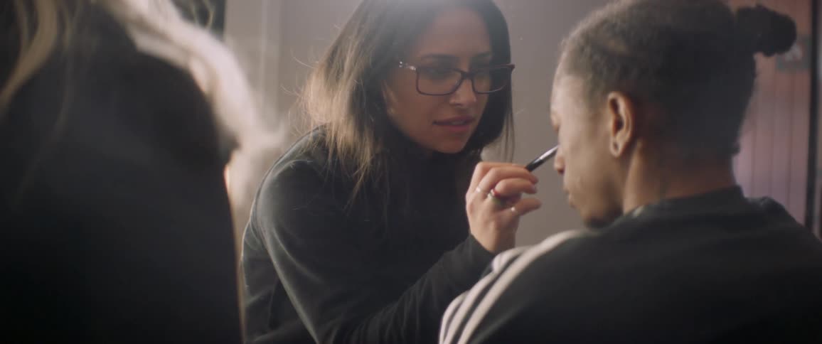 A makeup artist applies make up to a man