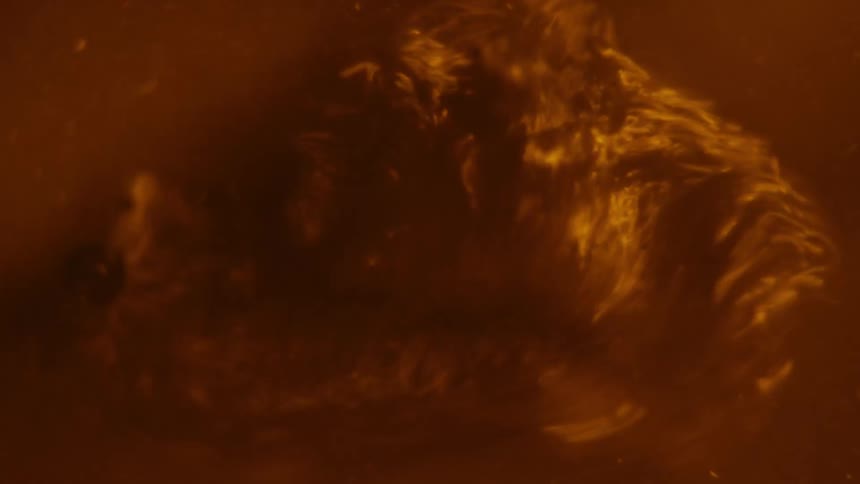 A reddish brown liquid bubbles and froths very vigorously