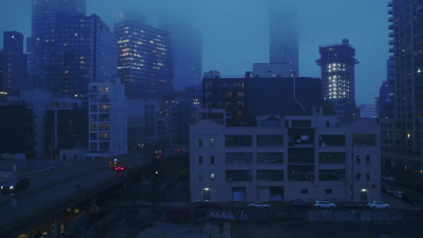 Traffic runs through the foggy city