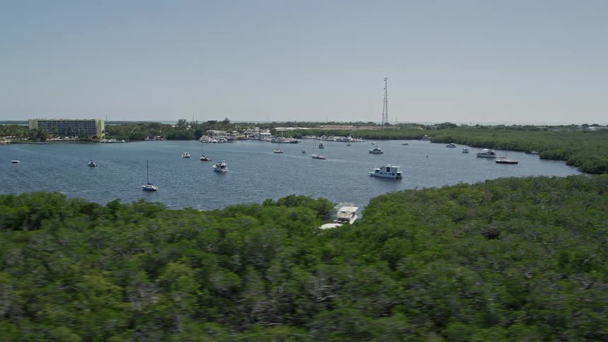 Aerial footage of sailboats and fishing boats navigating off the coast near Tavernier Florida during the summer