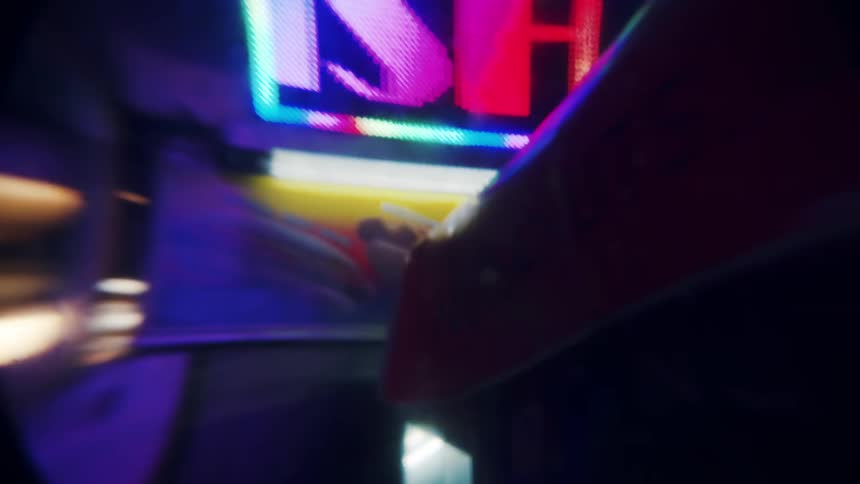 Groups of people walking past each other in a narrow walkway between street vendors with lights on the signs