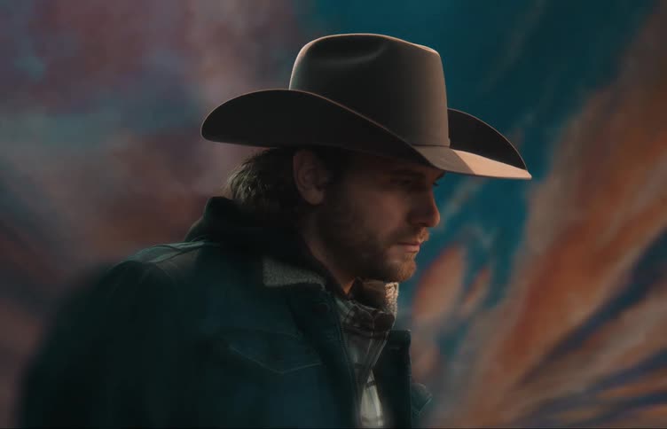 Side profile of man with brown hat beard and denim jacket