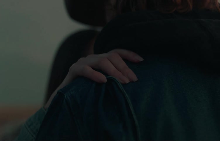 Close up of the faces of a happy young couple smiling while hugging at evening