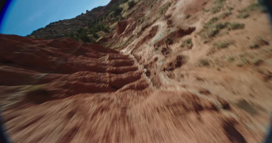 A mountain canyon in the bright sunlight as the camera whips past the rocks