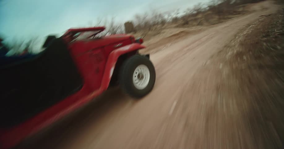 Red landcruiser drives on dirt road