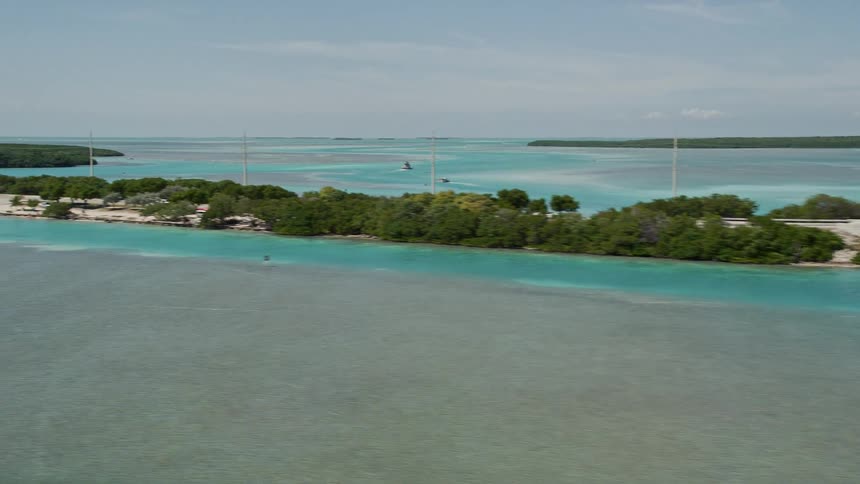 Aerial footage of vehicles travelling on the bridge connecting small islands along the Overseas Highway in Islamorada Florida during summer