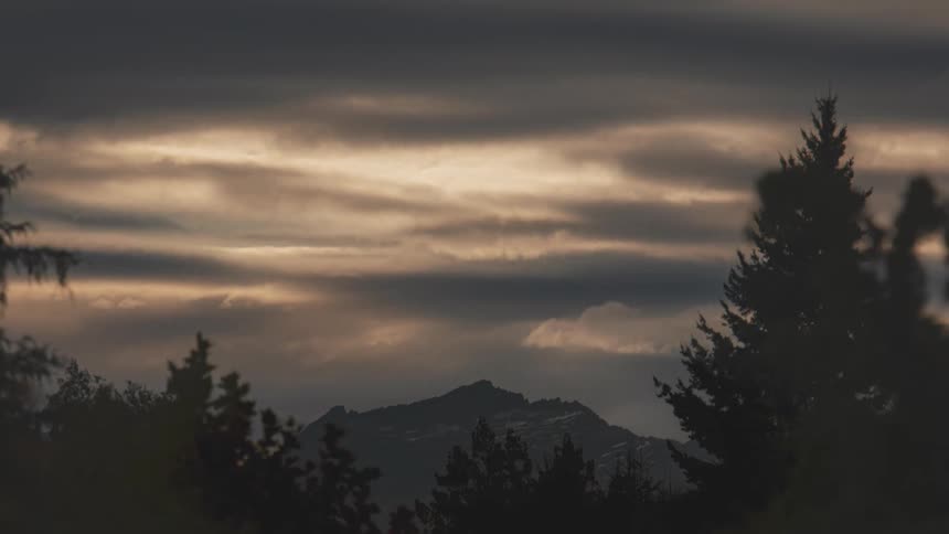 Time lapse of clouds rolling over the mountains in the countryside at nightfall