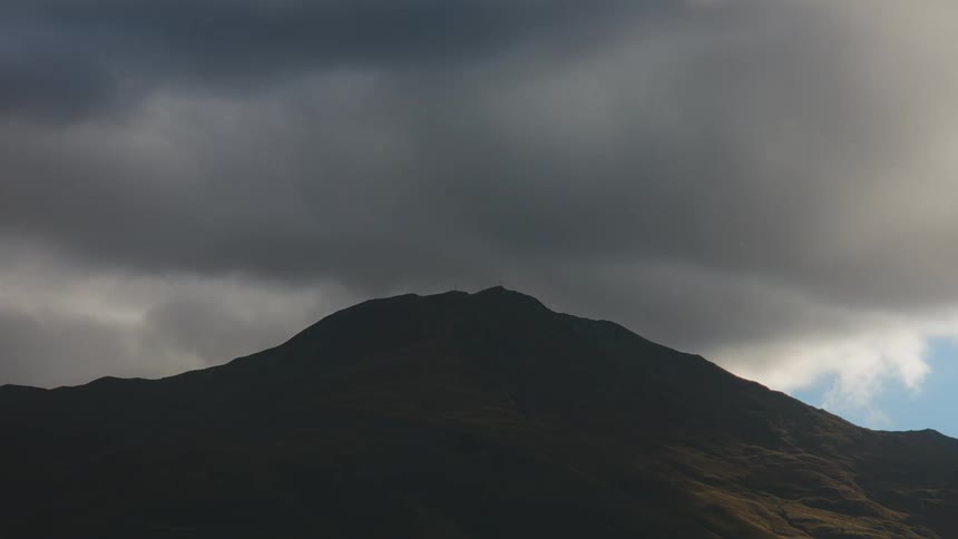 Clouds gather and darken over mountain