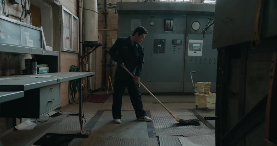 Fisheye view shows man mopping floor in factory