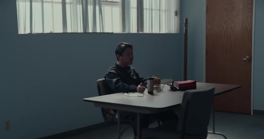 A man is sitting down and eating his lunch
