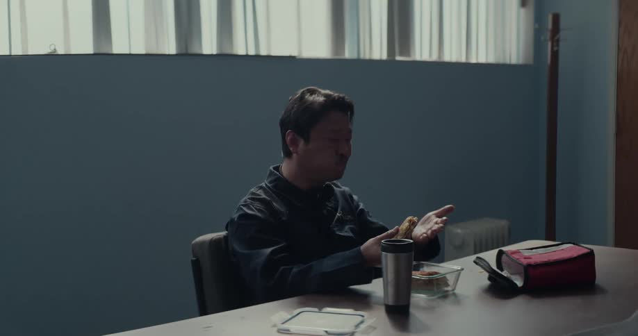 A man is sitting at a table and eating his lunch