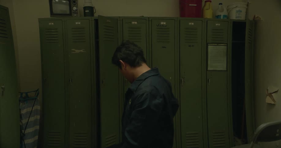 A focus of a man in a changing room while other people leaving