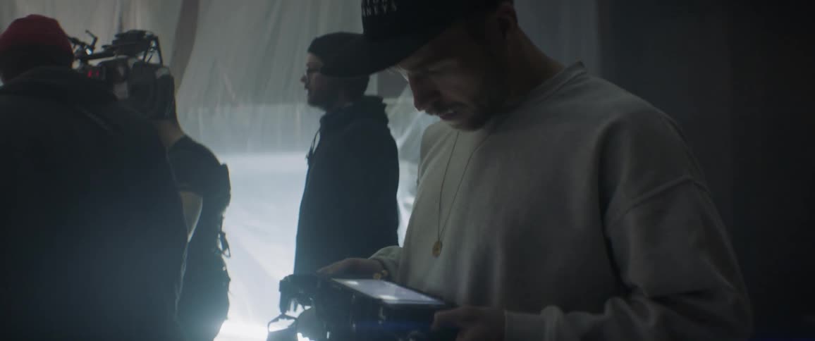 A group of people are filming a scene in the dark room