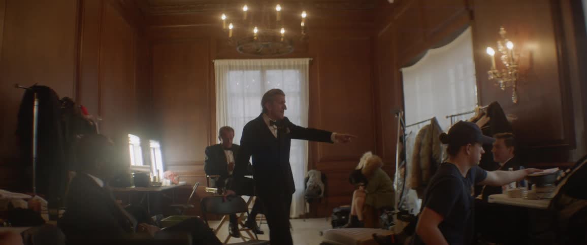 Man wearing a suit points and talks
